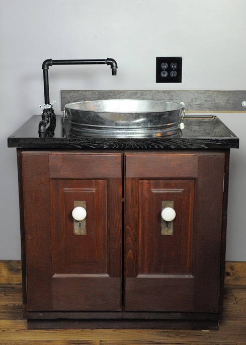 Bar sink built out of circa 1930 recycled doors, black pipe and a gavlanized bucket for sink