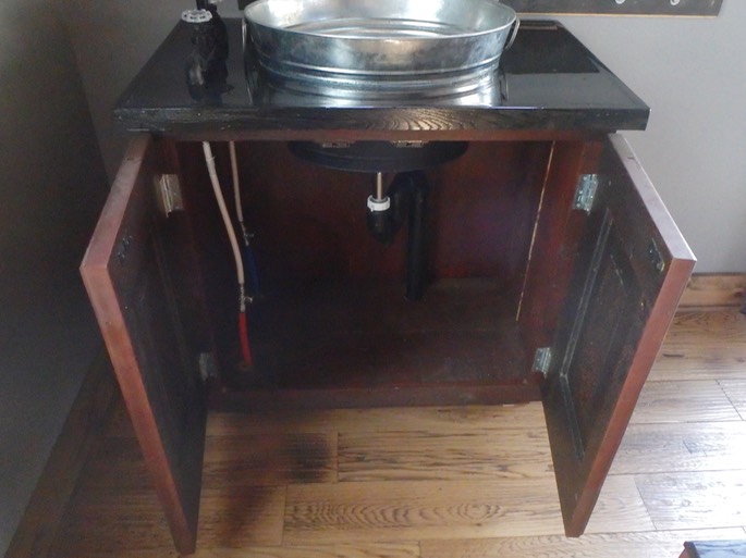 Bar sink built out of circa 1930 recycled doors, black pipe and a gavlanized bucket for sink